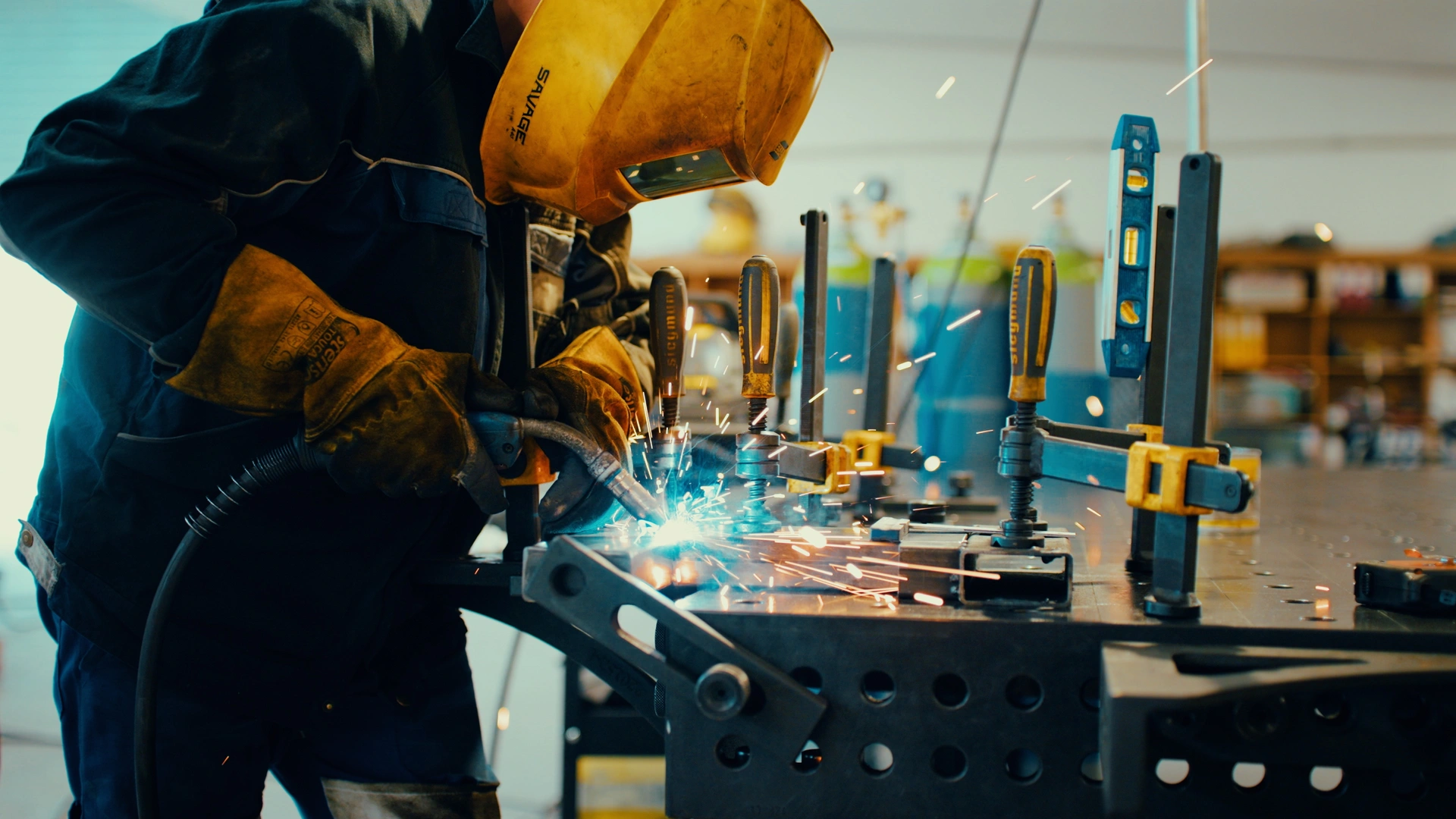 A welder assembling a metal frame in the workshop