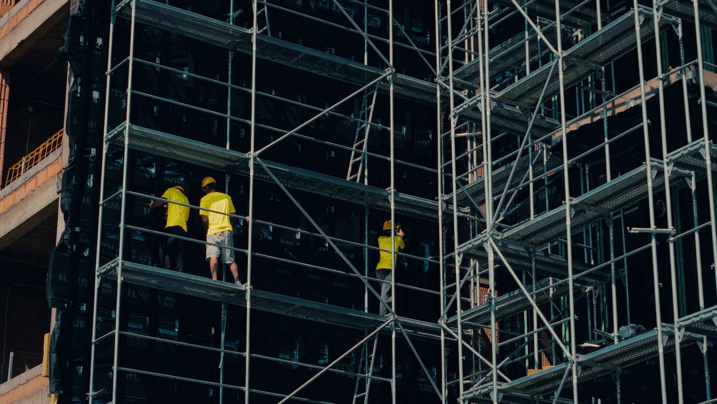 Greenwall installation team working on a scaffolded facade