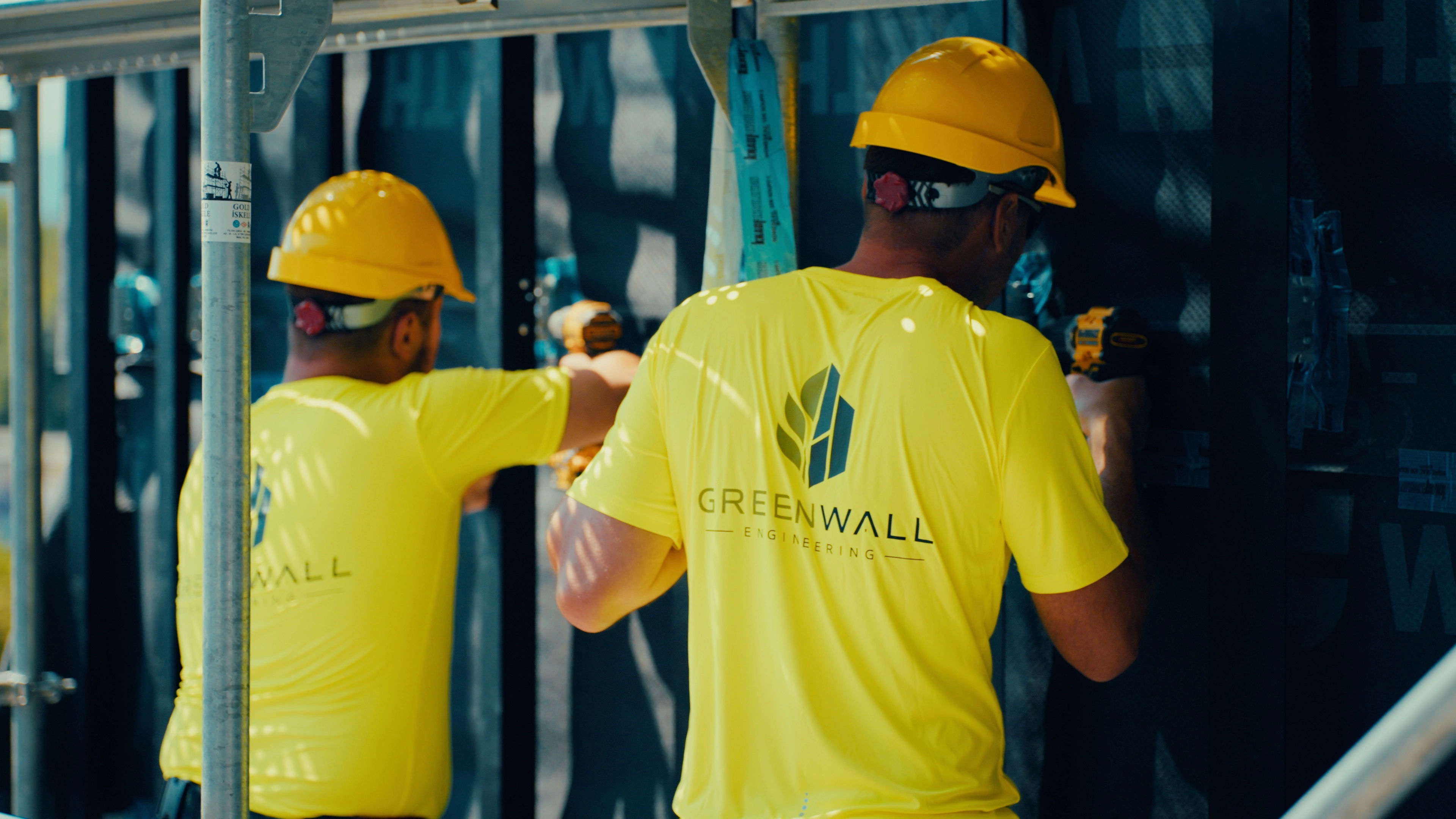 Two Greenwall installers fitting facade components